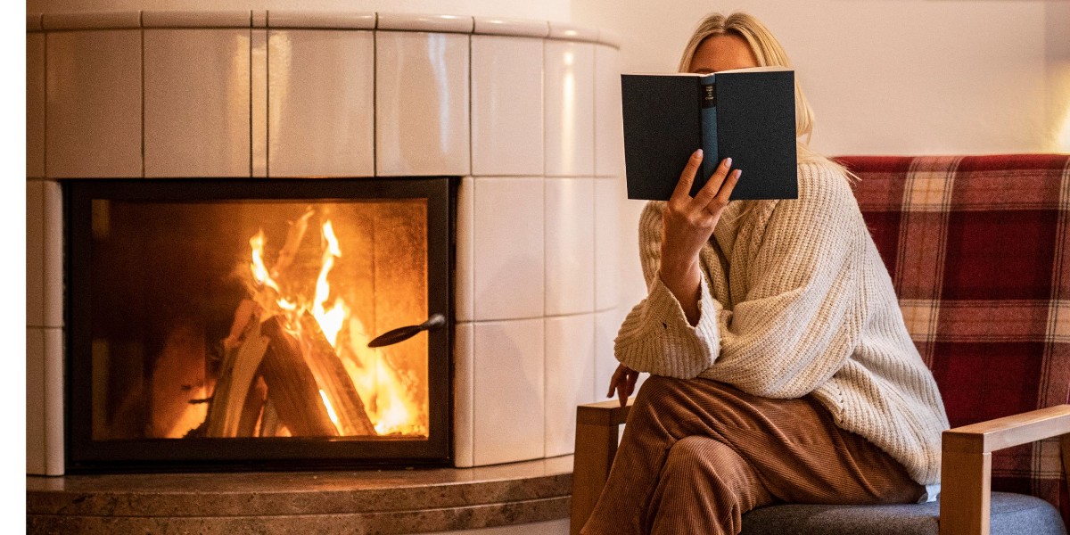 Frau liest ein Buch am Kamin