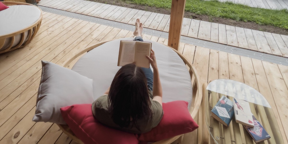 Frau liest entspannt ein Buch im Bootshaus im Weihrerhof