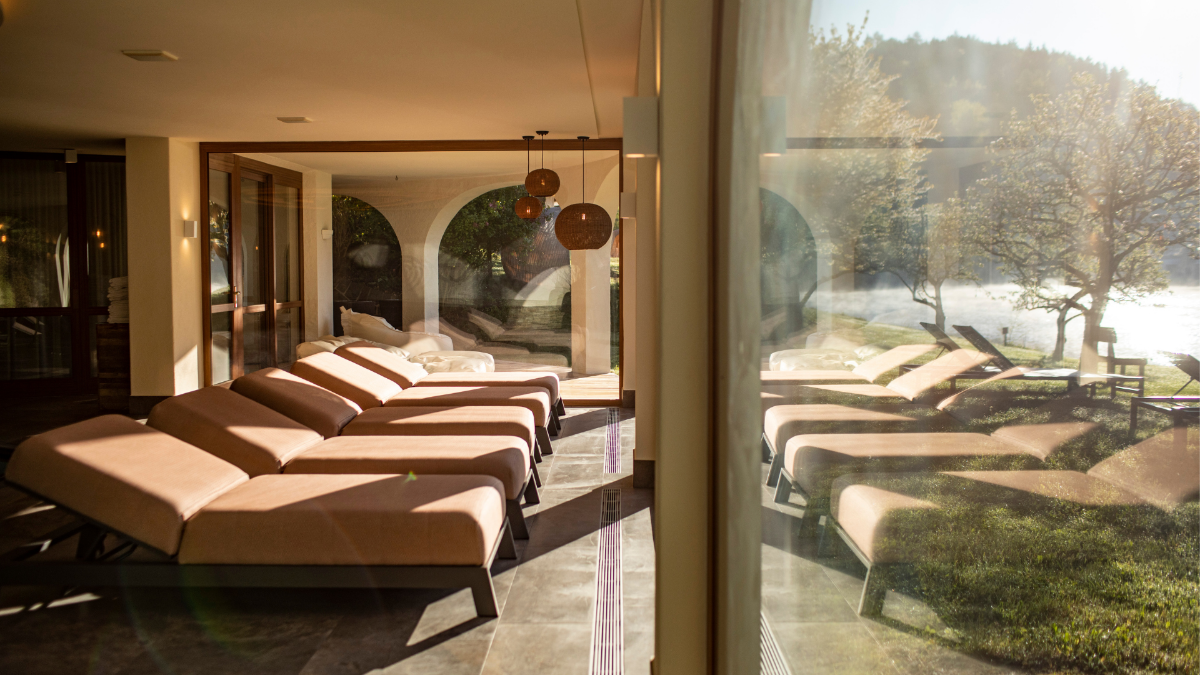Piscina dell’Hotel Weihrerhof con lettini relax e vista sul Lago di Costalovara.