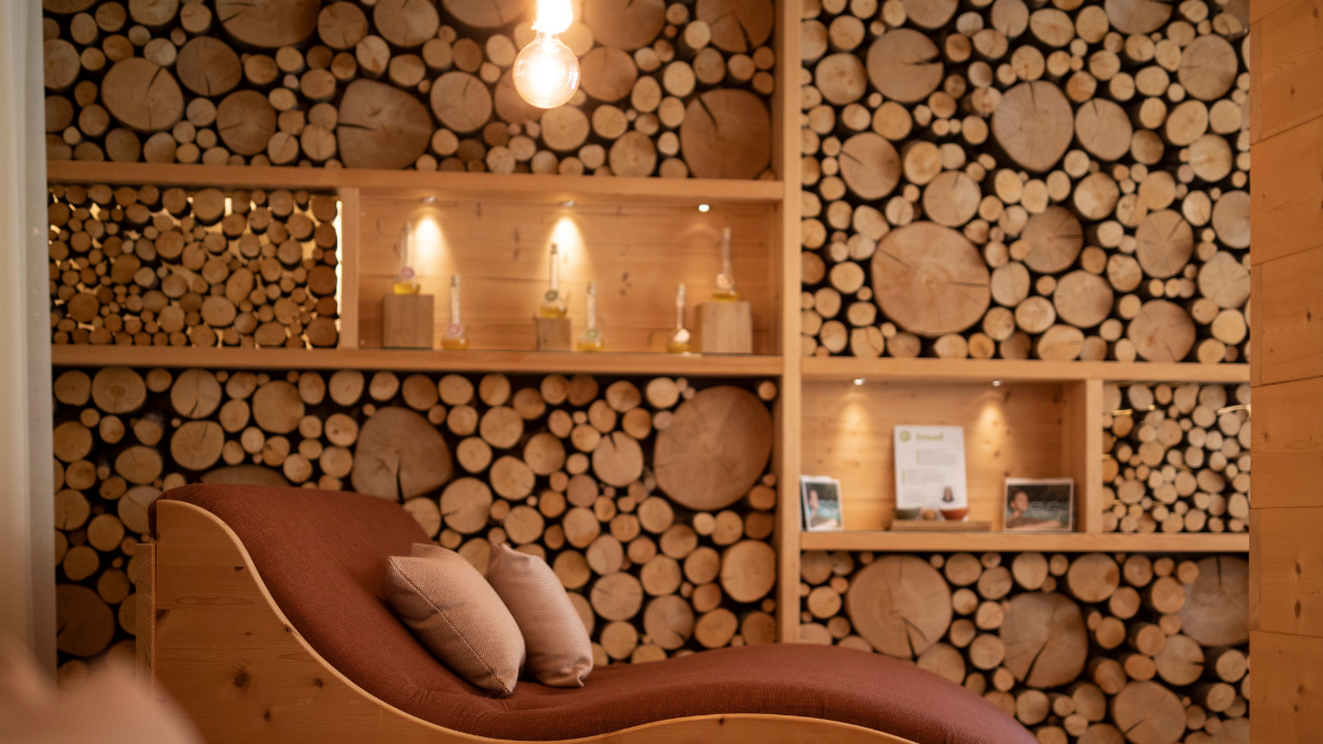Lettino relax nella SeaSpa dell’Hotel Weihrerhof davanti a una parete in legno naturale.